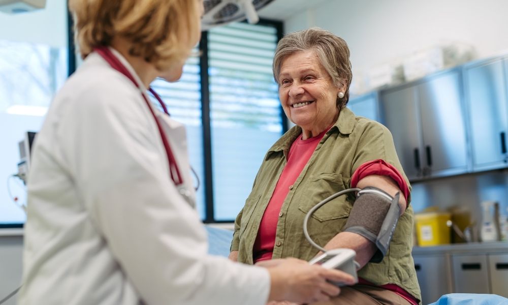 woman having blood pressure taken by nurse