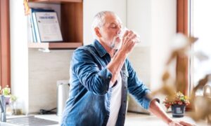 older adult drinking a glass of water